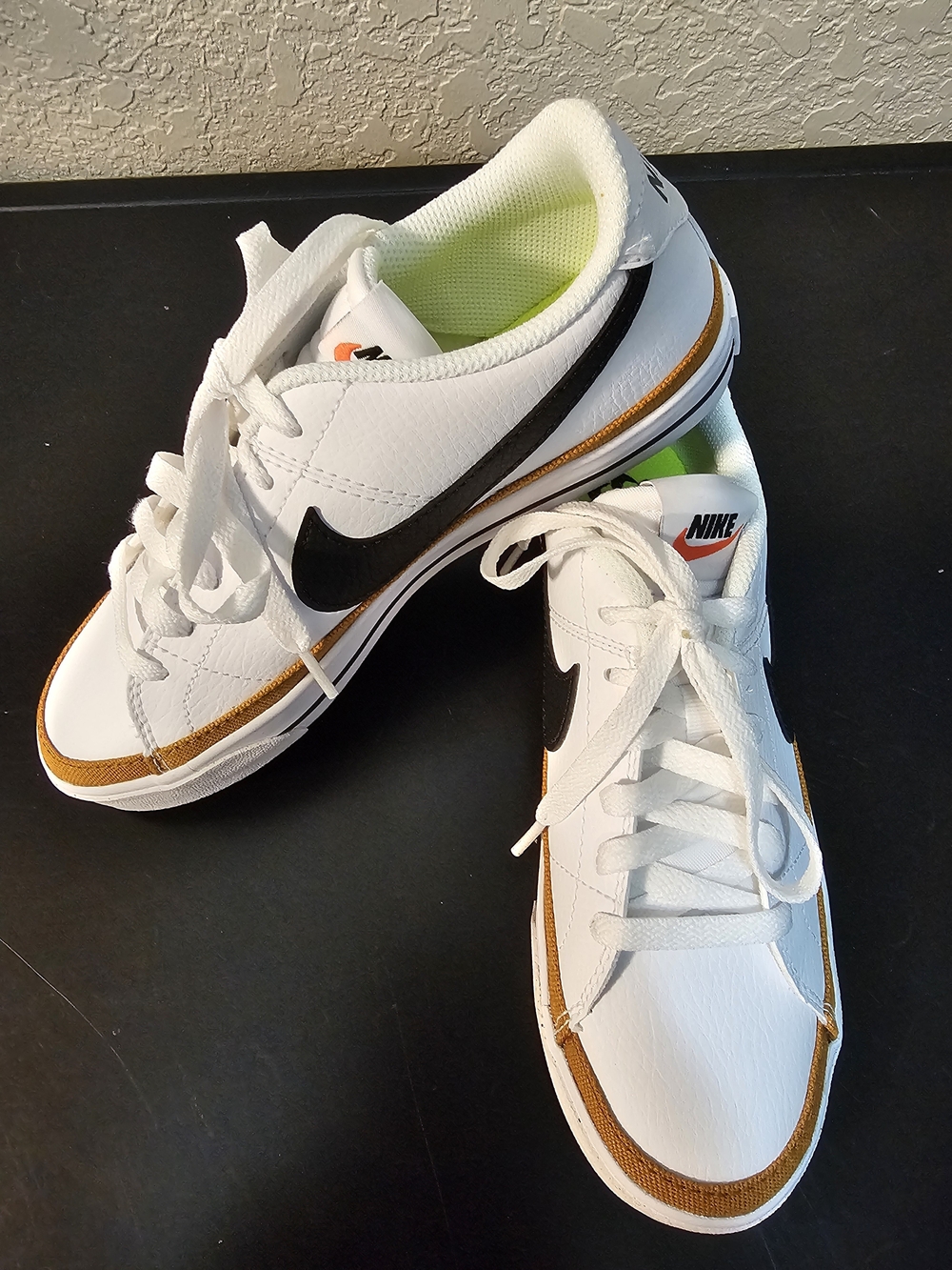 Nike White Low-Top Sneakers with Black Swoosh and Gold Trim